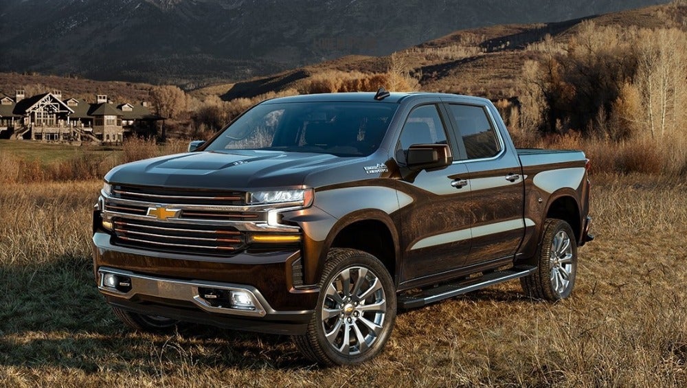 used Chevy silverado parked at sunset in front of rural town