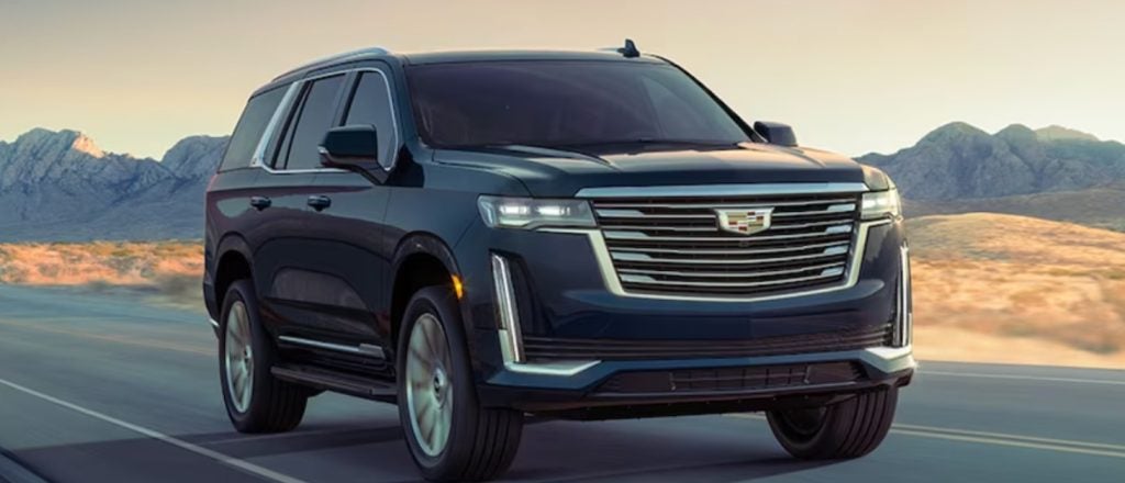 black Cadillac Escalade driving on a rural highway