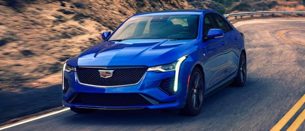 blue Cadillac CT4 driving on a rural highway