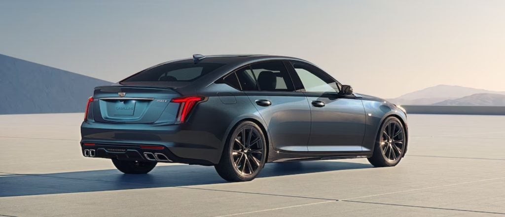 metallic blue Cadillac CT5 parked in a modern driveway