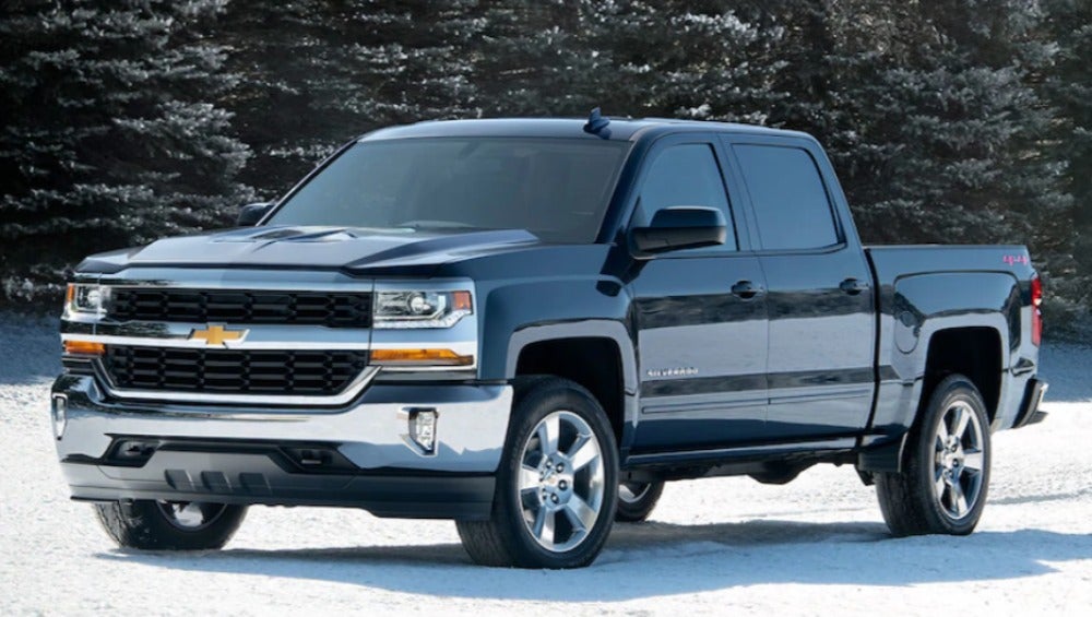Chevy pickup truck driving off road over snow