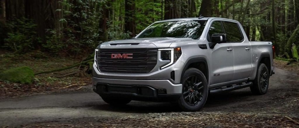 silver GMC Sierra 1500 driving through the woods