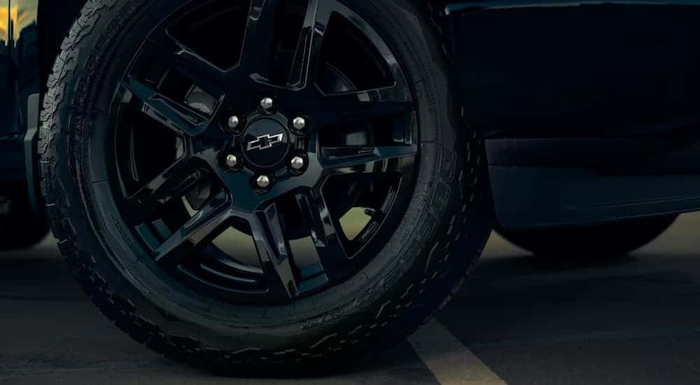 A close-up of a black rim and tire on a 2025 Chevy Silverado