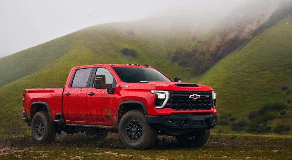 A red 2024 Chevy Silverado 2500 HD ZR2 Bison is shown from the front at an angle after leaving a Chevy Silverado 2500 dealer.