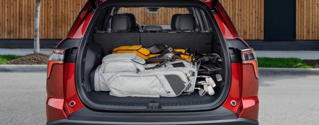 Golf clubs in the trunk of a red 2025 Chevy Equinox