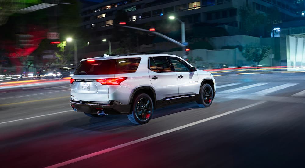 White 2023 Chevy Traverse Redline driving on a city street