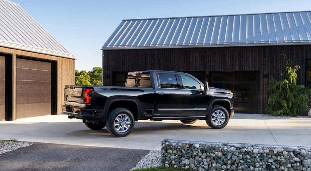A black 2024 Chevy Silverado 2500 HD High Country is shown from the side.