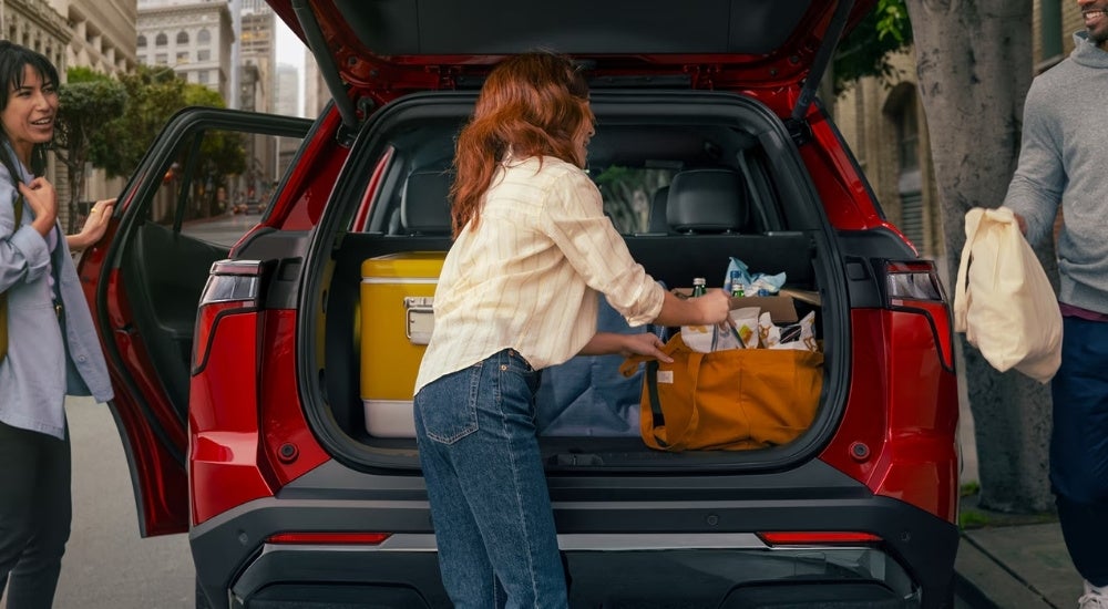 Person loading bags into a red 2026 Chevy Equinox RS