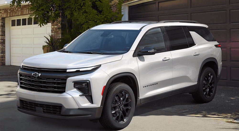 White 2026 Chevy Traverse parked in front of a garage