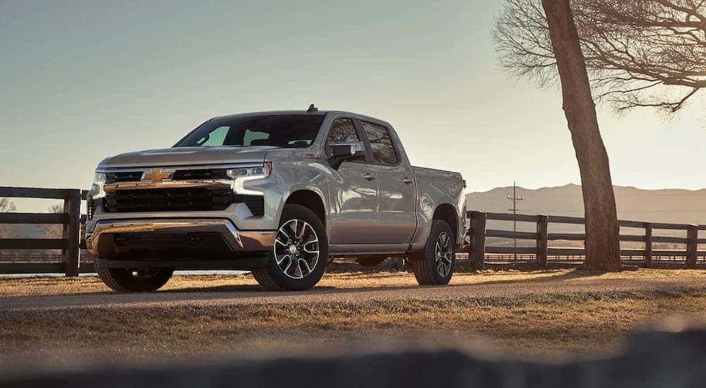 A silver 2023 Chevy Silverado 1500 Z71 is shown parked near a fence.