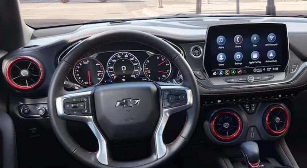 A steering wheel and dashboard are shown from the black interior of a 2024 Chevy Blazer.
