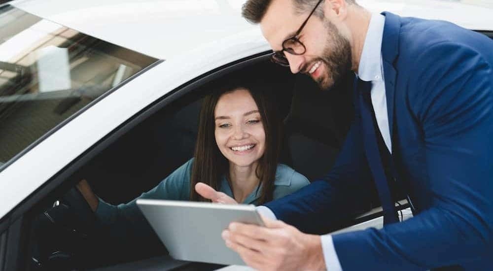 A salesman is shown holding a tablet near a customer