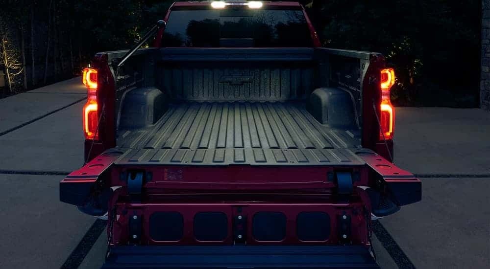 The open tailgate of a red 2024 Chevy Silverado 1500 is shown.