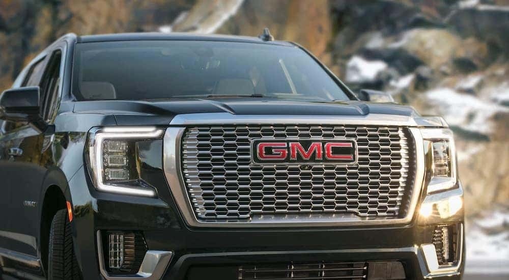 A close-up on the grille of a black 2021 GMC Yukon.