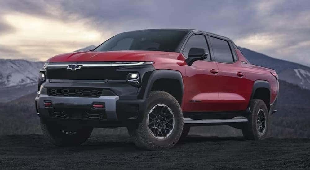 A red 2024 Chevy Silverado EV Trail Boss s shown parked off-road.