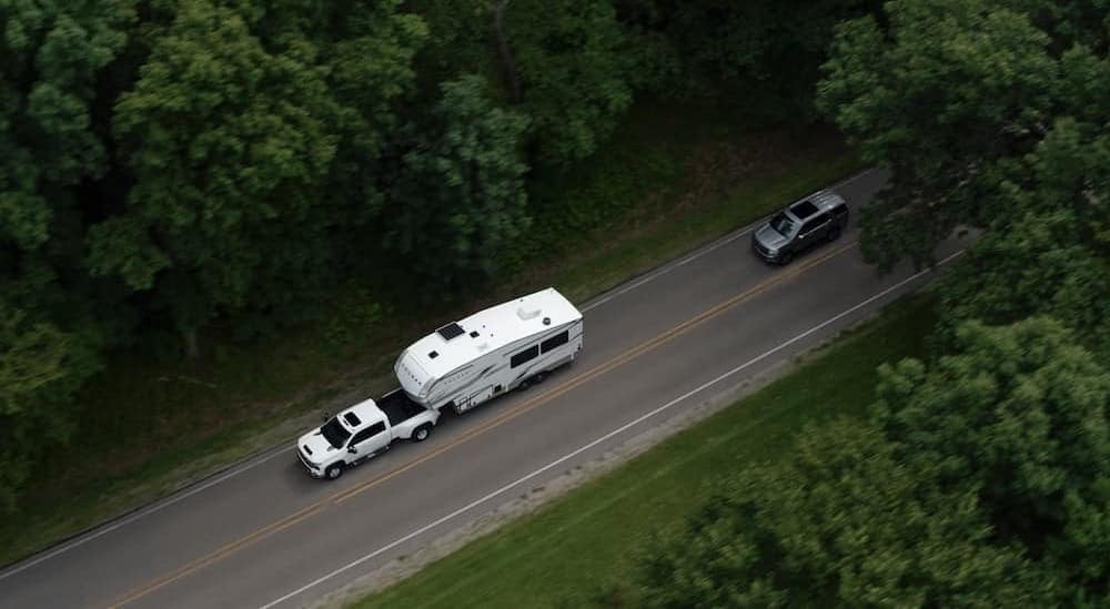Aerial view of a white 2026 Chevy Silverado 2500 HD towing a trailer.
