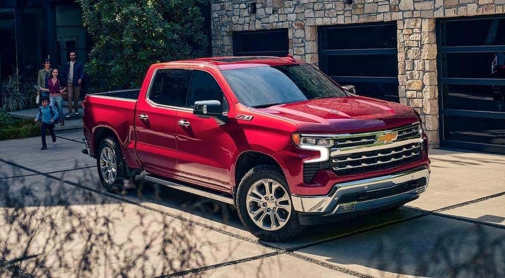 A red 2024 Chevy Silverado 1500 for sale near Hoover, parked in a residential driveway.