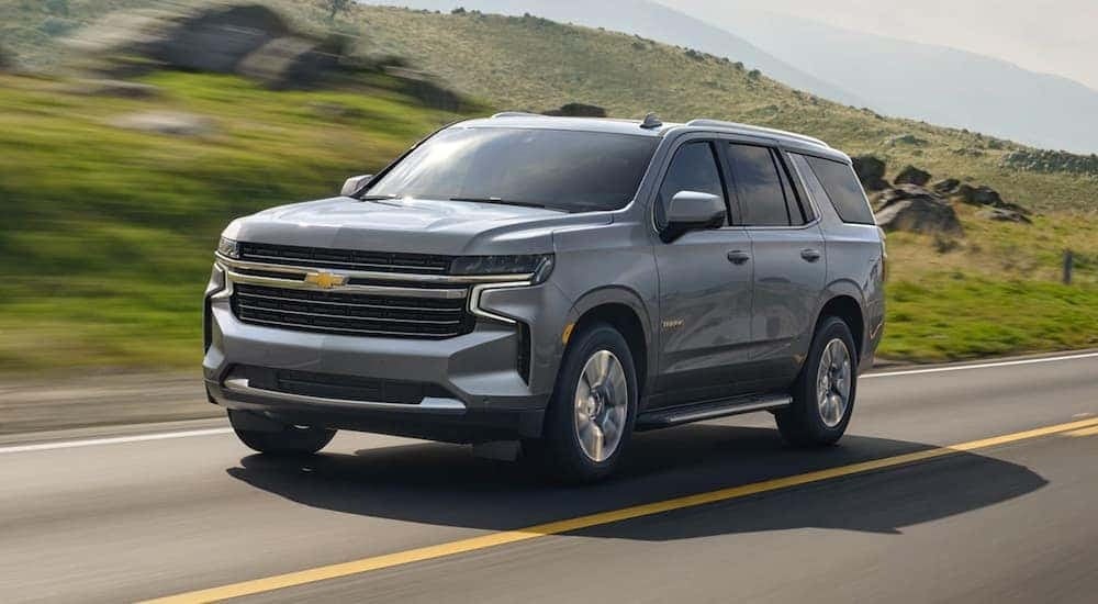 A gray 2021 Chevy Tahoe is shown driving on a highway.