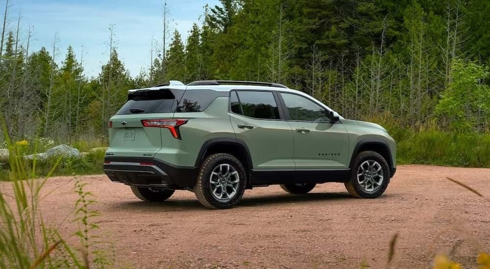 A green 2025 Chevy Equinox ACTIV for sale is parked off-road.