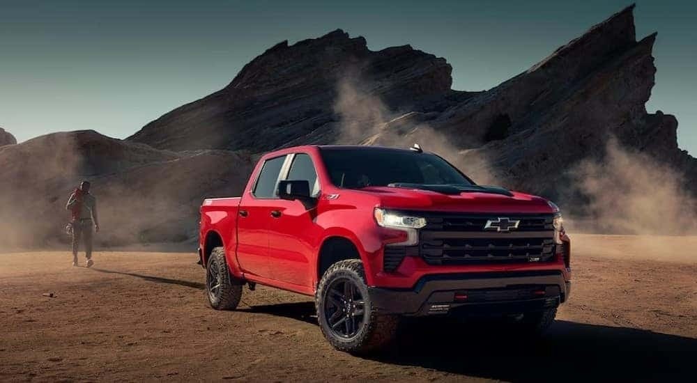 A red 2024 Chevy Silverado 1500 LT Trail Boss is shown parked after viewing Chevy trucks for sale near Pelham.