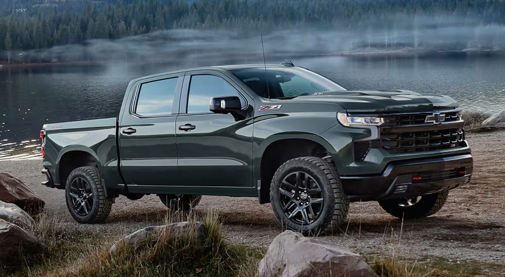 Grey 2026 Chevy Silverado 1500 parked off-road near a lake.