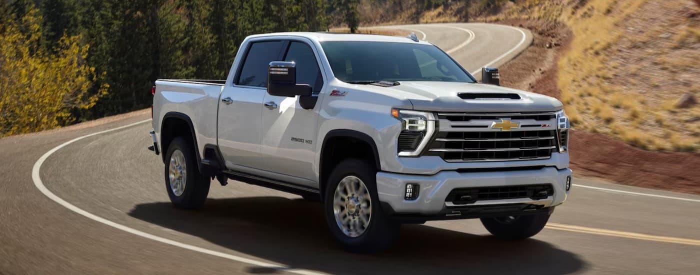 A white 2025 Chevy Silverado 2500 driving on a highway.