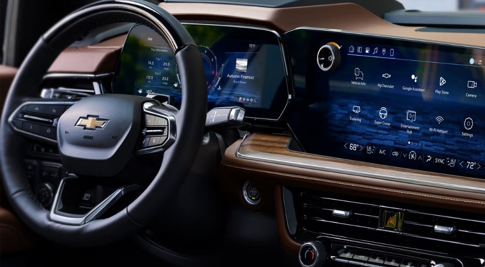 Close-up on the steering wheel in the brown interior of a 2025 Chevy Suburban High Country