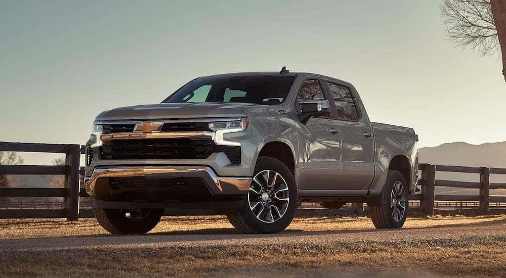 A silver 2024 Chevy Silverado 1500 LT L71 for sale near Gardendale parked near a fence.