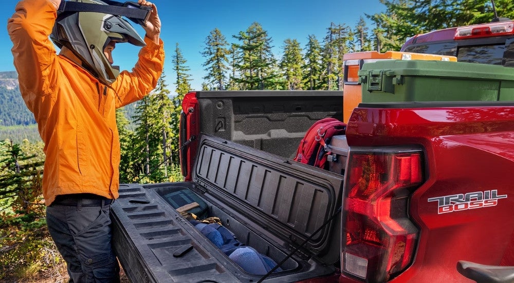Person near the tailgate of a red 2026 Chevy Colorado Trail Boss
