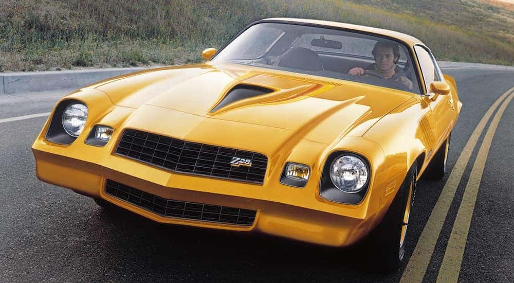 A yellow 1978 Chevy Camaro Z28 is shown from the front at an angle after researching how to 'sell my car'.