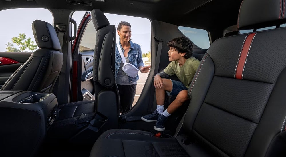 Parent helping a child out of a 2026 Chevy Traverse