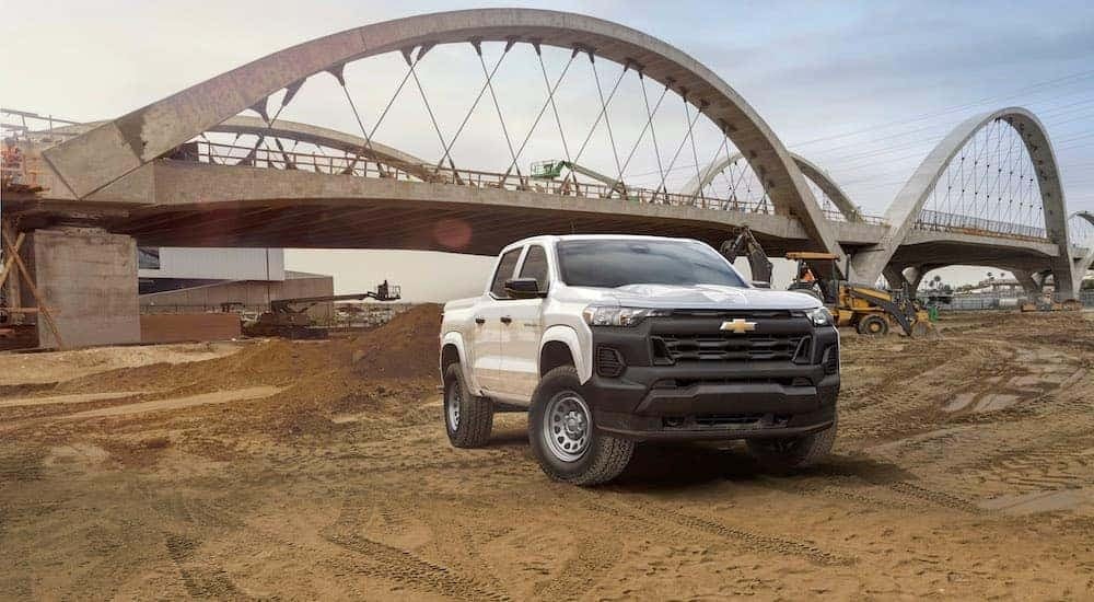 A white 2023 Chevy Colorado WT is shown from the front on a jobsite.