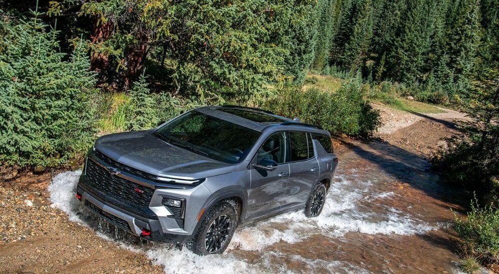 Silver 2026 Chevy Traverse Z71 for sale driving across a creek