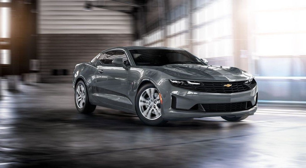 Grey grey 2022 Chevy Camaro driving through a warehouse
