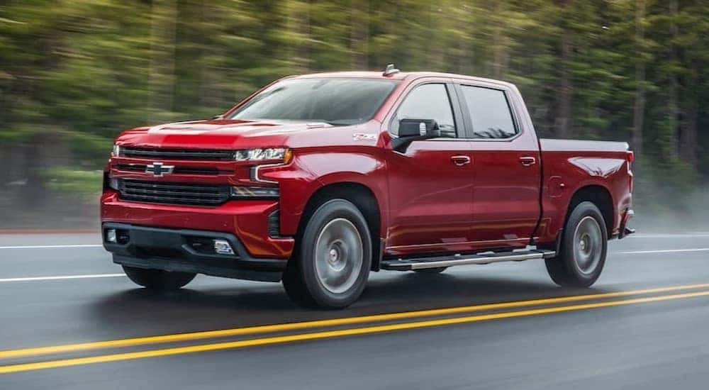 A red 2021 Chevy Silverado 1500 Z71 is shown driving on a highway.