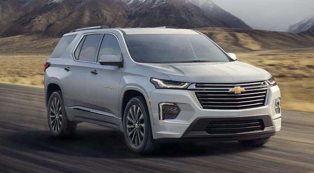 A silver 2022 Chevy Traverse is shown driving on a highway