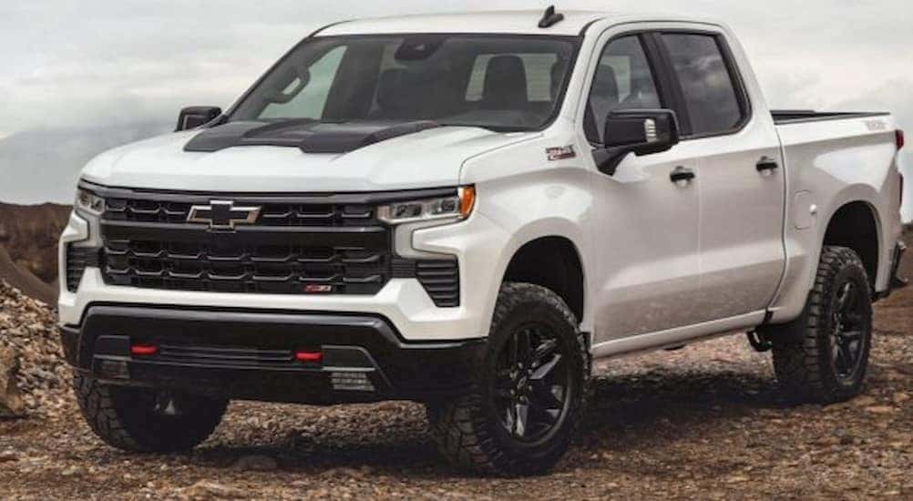 A white 2024 Chevy Silverado LT Trail Boss Z71 is shown parked on rocks.