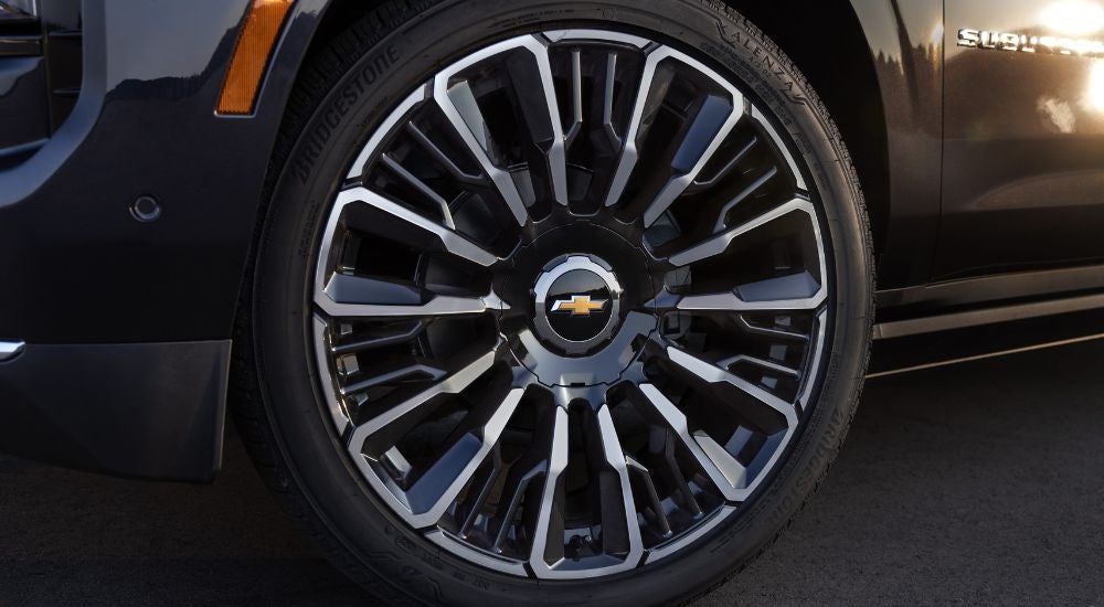 Front driver side wheel on a black 2025 Chevy Suburban High Country