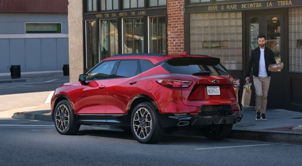 Red 2023 Chevy Blazer RS parked on a city street in front of a shop