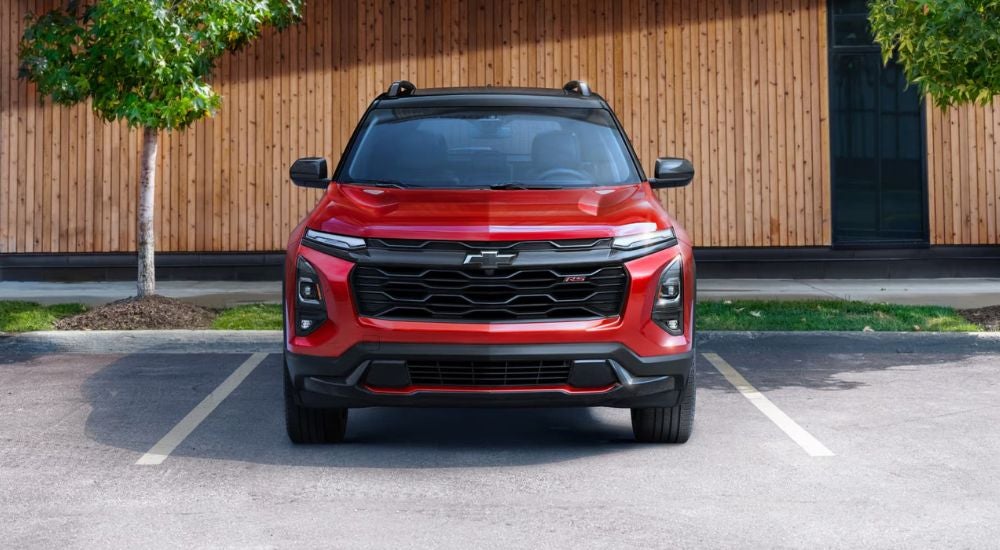 Red 025 Chevy Equinox RS parked in front of a fence