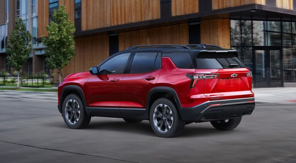 Red 2025 Chevy Equinox RS driving past a building