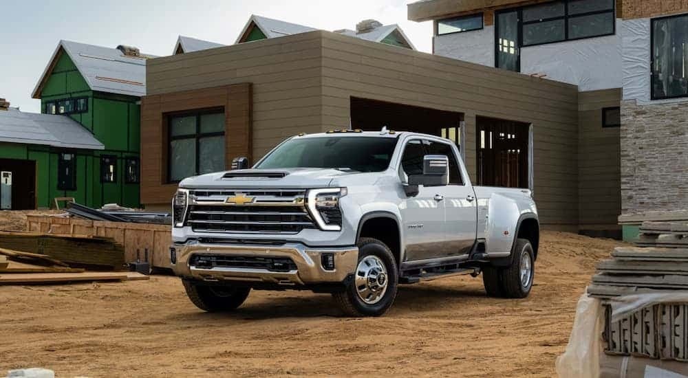 White 2026 Chevy Silverado 2500 HD parked in front of a house under construction