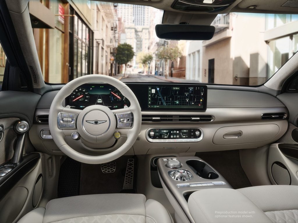 Interior view of a luxury Genesis car displaying the dashboard, steering wheel, and infotainment system, with a city street visible through the front windshield.