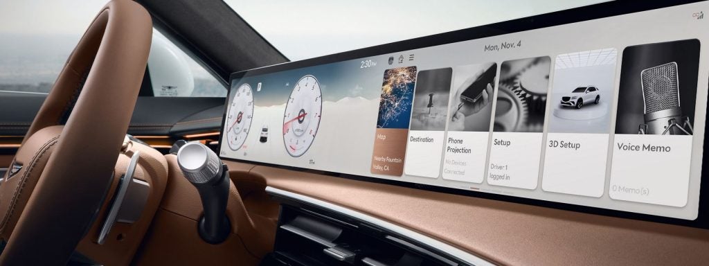 Genesis car dashboard with digital display, gauges, and partially visible steering wheel.