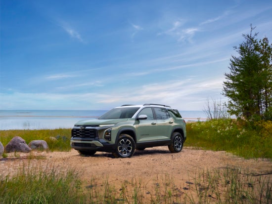 green Chevy Equinox parked in sand in front of the ocean