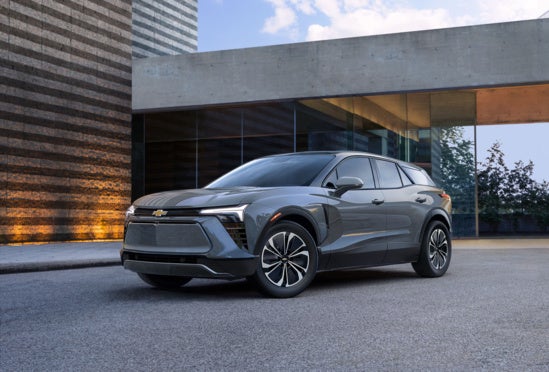 gray Chevy Equinox parked in the driveway of a modern home at dusk
