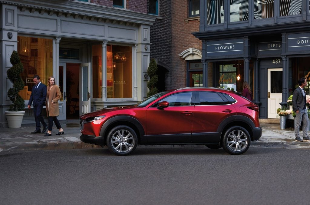 red Mazda CX-9 parked downtown in front of boutique shops
