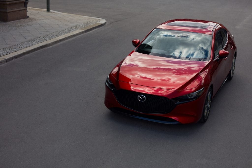 birds eye view of red Mazda3 driving downtown