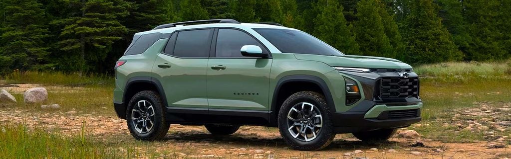 Green Chevrolet Equinox SUV parked on a rugged forest trail.
