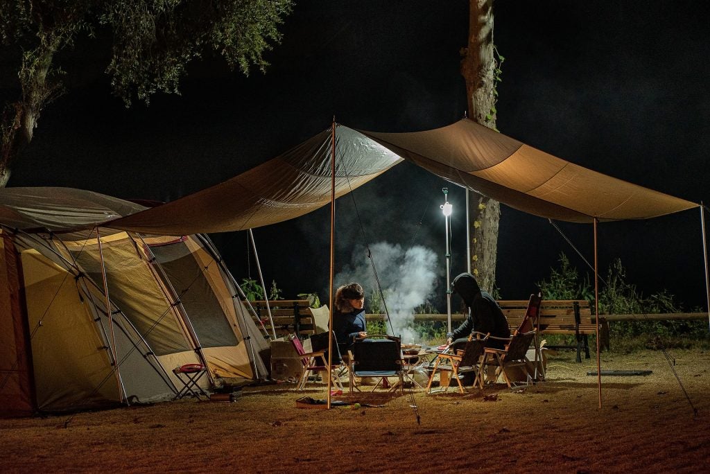 People camping under a tent.